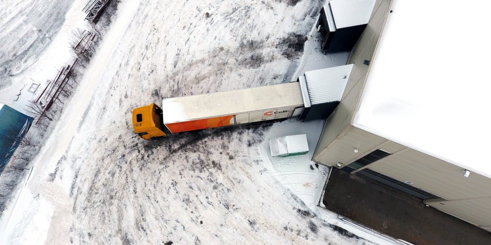 Looking over a branded ColliCare trailer from above parked to the storage, loading and unloading goods 