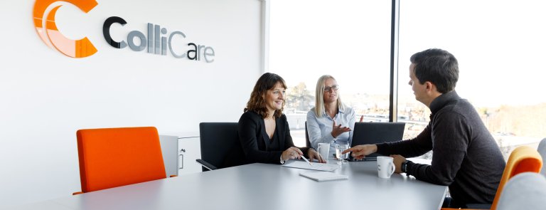 Three people having a business meeting in a ColliCare office