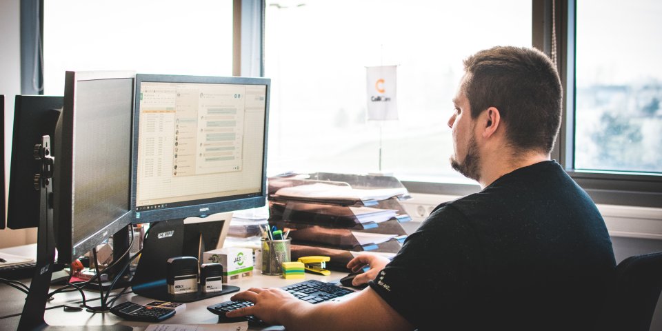 ColliCare employee on his computer in the office, working on finding the best solutions for the customers